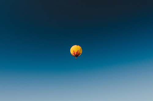 yellow worm's eye view photography of yellow hot air balloon on the skies fly